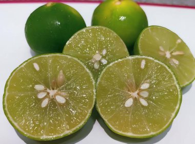 Limonlu ve limonlu bir tabağın fotoğrafı. Limon ve limonlar kırmızı çizgili beyaz bir tabakta..