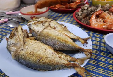 Masadaki bir tabak balığın diğer tabaklarla fotoğrafı..