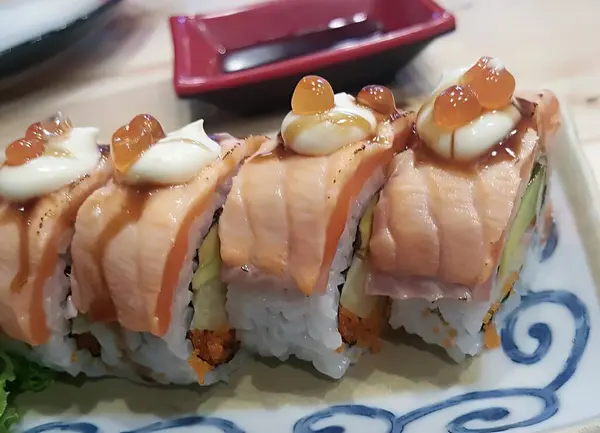 寿司卷上有酱汁和酱汁 盘上有寿司卷 桌上有酱汁的照片 — 图库照片