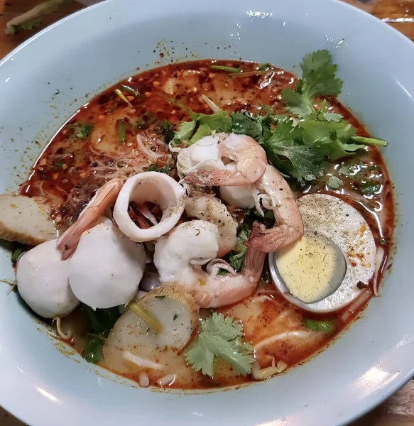 一碗有海鲜和鸡蛋的汤 一碗有海鲜和蔬菜的红色肉汤的照片 — 图库照片