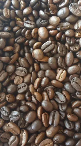 a photography of a pile of coffee beans with a white background, espresso coffee beans are piled up in a pile.