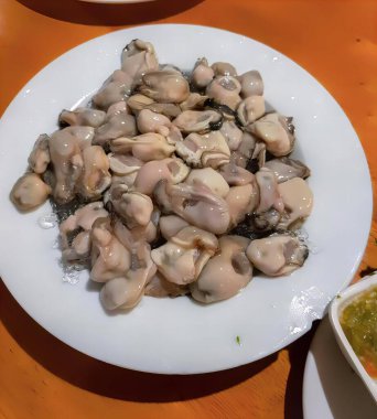 Masada soslu istiridye tabağı, soslu istiridye tabağı ve masada bir kase çorba..