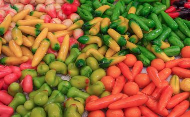 sergilenen çeşitli biber ve diğer sebzelerden oluşan bir fotoğraf.