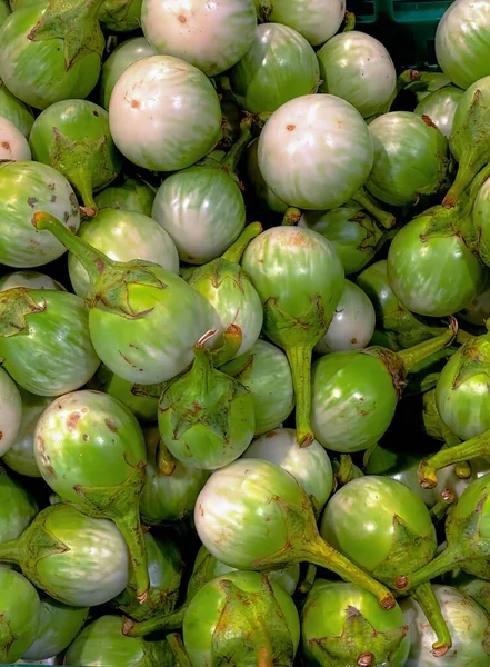 a photography of a pile of green and white figurines, globe artichokes are green and white in a pile.
