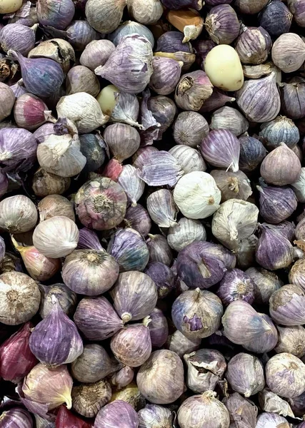 a photography of a pile of onions with a white onion in the middle, mortared onions are piled up in a pile on a table.