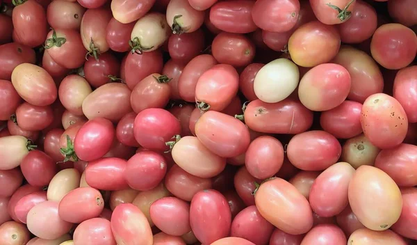 Una Fotografía Montón Tomates Con Hojas Verdes Ellos Hippeatries Rosa — Foto de Stock