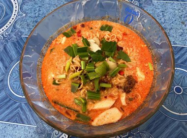 Erişte ve sebzeli bir kase çorbanın fotoğrafı. Erişteli çorba kasesi, et ve kırmızı soslu sebzeler..