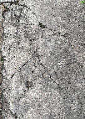 Ortasında yangın musluğu olan kırık bir kaldırımın fotoğrafı..