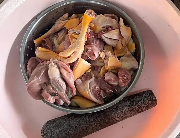 a photography of a bowl of food with a wooden stick on a plate, hot pot of meat and vegetables on a plate with a wooden stick.