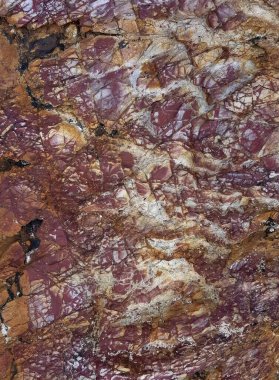 Çok büyük kırmızı ve beyaz boyalı bir kayanın fotoğrafı..