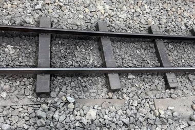 Taşlı ve çakıllı bir tren rayının fotoğrafı. Yolcu vagonu çakıllı, taşlı ve çakıllı..