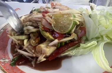 Çatallı bir tabak yemeğin, çatallı bir tabak yemeğin ve salatanın fotoğrafı..