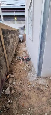 Yırtılmış ve üzerinde çalışılan bir duvarın fotoğrafı. Ortasında bir duvar ve yangın musluğu olan teraslı bir alan..