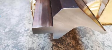 Üzerinde bıçak olan metal bir nesnenin fotoğrafı, metal tabanlı metal bir masanın üzerindeki abajur..