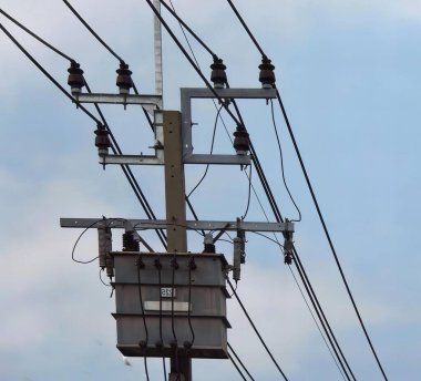 Telefon direği ve kabloları olan bir elektrik direğinin fotoğrafı..