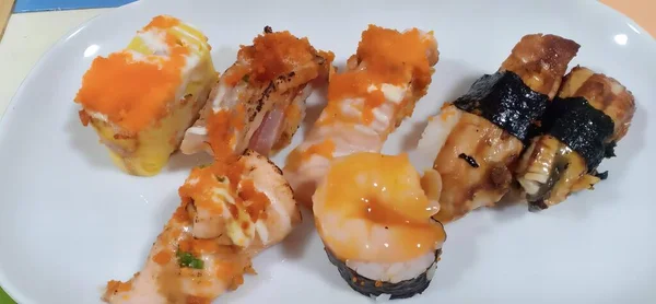 テーブルの上の寿司とエビのプレートの写真 フォーク付きの白いプレートの寿司とエビのプレート — ストック写真
