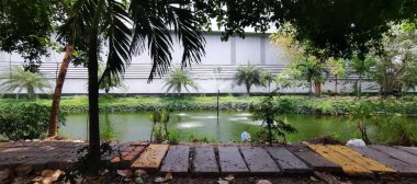 Çeşmeli bir göletin ve arka planda bir binanın fotoğrafı..