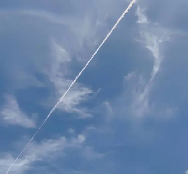 a photography of a plane flying in the sky with a contrail in the sky, space shuttle flying in the sky with contrails in the sky.
