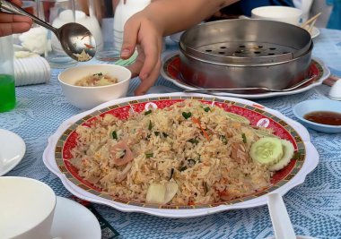 Bir tabak yemeğin fotoğrafı, servis yapan bir kişinin olduğu bir tabak yemek, masada servis eden birinin olduğu bir tabak..