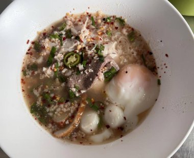 Kızarmış yumurta ve etle bir kase çorbanın, et, sebze ve pirinçli konsomeadenin fotografı..