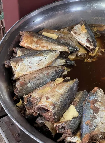 在桌上放满了鱼和酱汁的平底锅里 热锅里放满了酱汁的鱼的照片 — 图库照片