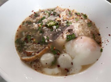 Et ve sebzeli bir kase çorbanın, masada et ve sebzelerle konsomeadenin fotoğrafı..