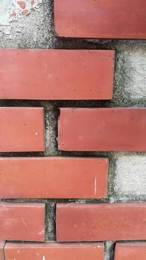 İçinde küçük bir delik olan tuğla bir duvarın fotoğrafı. Tuğlalardan yapılmış bir duvar ve çimentodan yapılmış bir mektup kutusu..