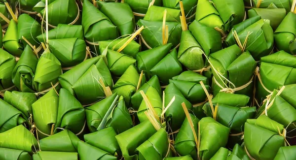 a photography of a pile of green leaves with a bunch of bananas, spiraled green leaves are piled together in a pile.