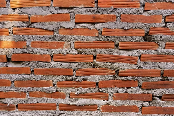 a photography of a brick wall with a red brick in the middle, stone wall with red bricks and cement blocks in a brick wall.