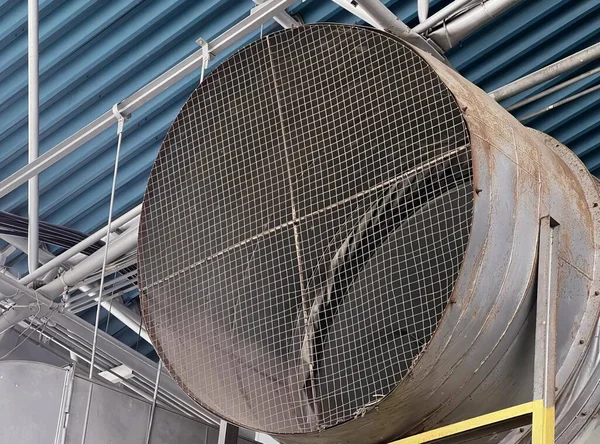 a photography of a large metal tube with a metal mesh covering it.