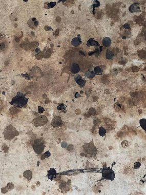 Üzerinde lekeler olan kirli bir zeminin fotoğrafı, asma kilitli siyah lekeli ve paslı beton yüzey..