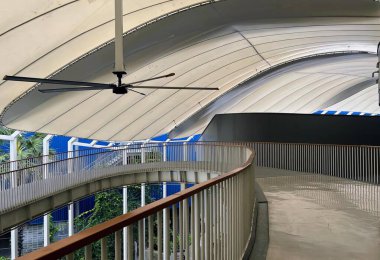 Bir binanın tavanından sarkan bir vantilatör, tavan vantilatörü ve korkuluğu olan bir binanın kasası..