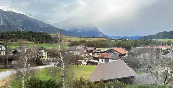 背景に山のある小さな町の写真 背景に山がある村のアルプスの写真 — ストック写真