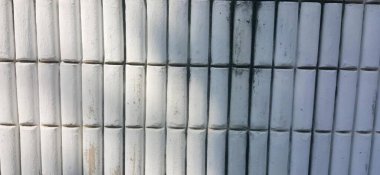 Siyah çizgili beyaz bambu bir çitin fotoğrafı, beyaz bambu direkleri üst üste dizilmiştir..