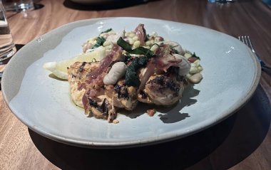 Çatal ve bıçakla bir tabak yemeğin fotoğrafı. Masada çatal ve bıçakla bir tabak yemek var..