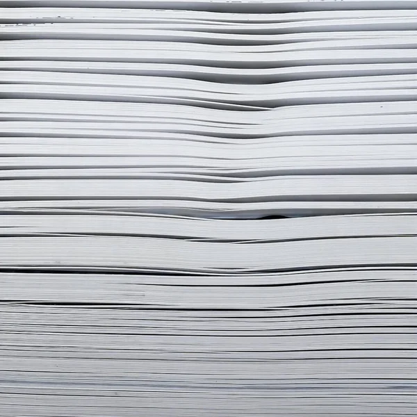 a photography of a stack of papers with a single red object in the middle.