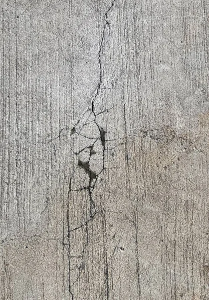 a photography of a fire hydrant sitting on top of a cement wall, concrete wall with cracks and cracks in it.