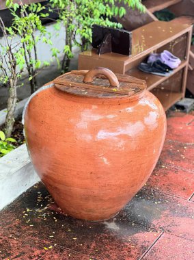 Büyük kilden bir tencere ve sapı var..