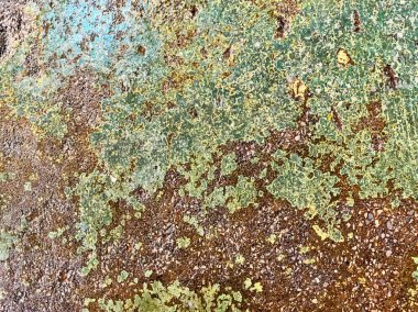 Yeşil ve mavi desenli paslı metal bir duvar..