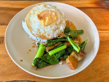 Kızarmış yumurta ve sebzeli bir tabak yemek..