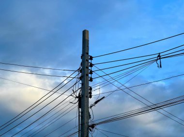 Kablolu bir telefon direği ve bulutlu bir gökyüzü..