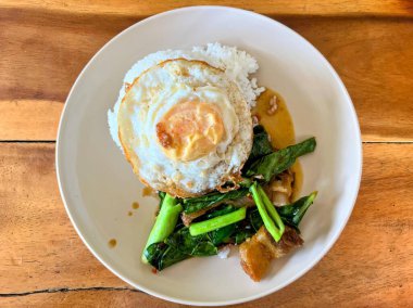 Kızarmış yumurta ve sebzeli bir tabak yemek..