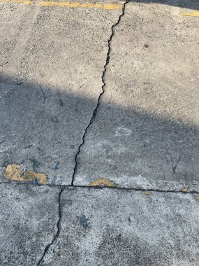 Bir yangın musluğunun, yerde bir çatlakla birlikte kaldırımda çekilmiş fotoğrafı..