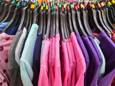 Farklı renkte gömlekleri olan bir elbise rafının fotoğrafı..