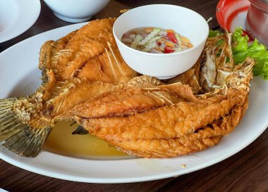 Bir tabak soslu kızarmış balığın fotoğrafı..