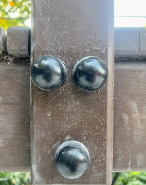 Arka planda ağaç olan metal bir nesnenin yakın plan fotoğrafı..