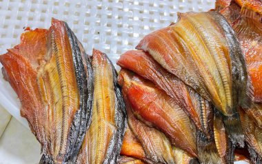 Plastik tepsinin üstünde oturan bir grup balığın fotoğrafı..