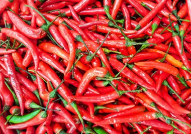 a photography of a pile of red hot peppers with green stems. clipart