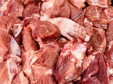 Bir masanın üzerinde duran et yığınının fotoğrafı..