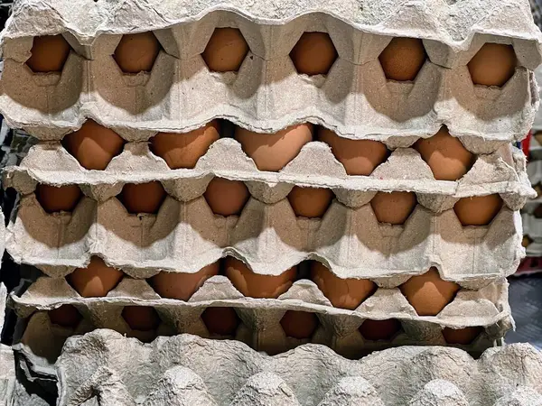 a photography of a stack of eggs in a carton.